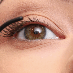 Primo piano di una modella che applica le ciglia a grappolo